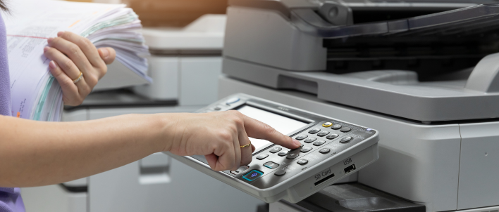 The hand and arm of a person using a copy machine