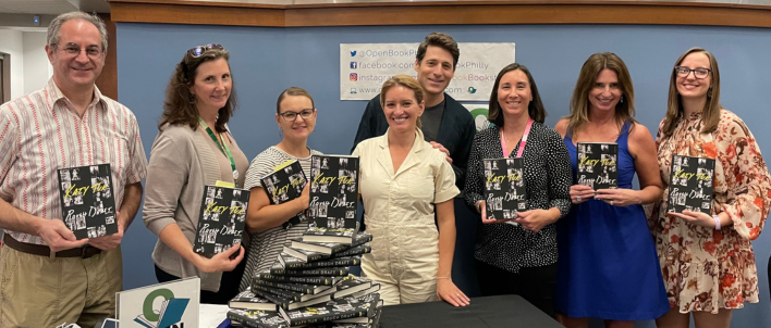 Eight people standing in a row holding copies of Katy Tur's book